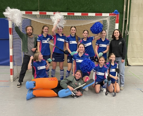 Bronzemedaillengewinnerinnen der u14. Zu sehen ist das team der u14 und die Beteruer:innen in einem Tor, wie sie sich über ihre Bronzemedallie freuen